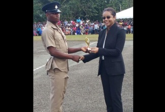 Attorney General,  Marlene Malahoo Forte (Right), presents the trophy for best recruit to Romaine Howell. Occasion was the passing out parade for 226 Jamaica National Service Corps (JNSC) soldiers, held on Saturday (February 10), at the Moneague Training Camp in St. Ann.