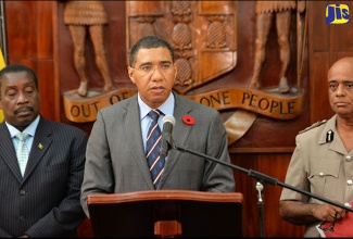 Prime Minister, the Most Hon. Andrew Holness (centre), addresses a press conference at Jamaica House on Tuesday (October 17), where he declared Denham Town in West Kingston as the second Zone of Special Operations (ZOSO). Others (from left) are Minister of National Security, Hon. Robert Montague and Commissioner of Police, George Quallo.

