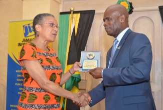 Deputy Governor General, the Hon. Steadman Fuller receives a plaque from Chairman of the Jamaica Information Service (JIS) Advisory Board, Ms. Fae Ellington, at the 2015 JIS Heritage Essay Competition Awards Ceremony, held on November 27, at King’s House.