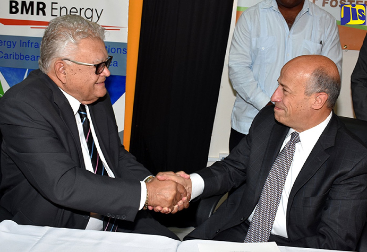 Minister of Industry, Commerce, Agriculture and Fisheries, Hon. Karl Samuda (left), shakes the hand of President and Chief Executive Officer (CEO), BMR Energy LLC, Bruce Levy, following the signing of a memorandum of understanding (MOU) for the development of renewable energy infrastructure at the Monymusk Sugar Estate in Clarendon. The signing took place at the offices of the Ministry in New Kingston on November 7.  