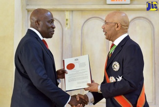 Governor-General, His Excellency the Most Hon. Sir Patrick Allen (right), presents the Instrument of Office to Chief Justice, Hon. Bryan Sykes, during the swearing-in ceremony at King’s House on Thursday (March 1).