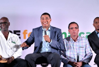 Prime Minister, the Most Hon. Andrew Holness (2nd left), has a light moment, during the second HOPE for Jamaica town hall meeting, organised by the Ministry of Economic Growth and Job Creation, at the old Goodyear factory complex in Morant Bay on Thursday. July 13.. Others (from left) are Local Government and Community Development Minister, Hon. Desmond McKenzie; Minister without Portfolio, Ministry of Economic Growth and Job Creation, Hon. Daryl Vaz; and State Minister for Education, Youth and Information, Hon. Floyd Green.