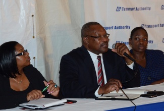 Managing Director of the Transport Authority of Jamaica (TAJ), Donald Foster (centre) responds to a question raised at a public consultation held on June 11 at the Holy Cross Church on Half-Way-Tree Road in Kingston. Listening are Manager, Communication, and Customer Services, TAJ, Petra-Kene Williams (right); and President of the Route Taxi Association of Jamaica, Sophia Campbell.