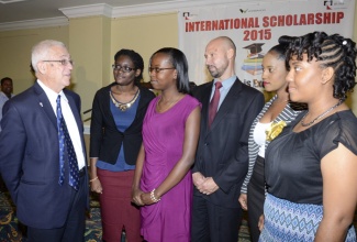 Minister of Education, Hon. Rev. Ronald Thwaites (left), congratulates some of the recipients of UC Rusal scholarships, valued at over $100 million, to study in Russia, at the presentation ceremony held today (November 24), at the Knutsford Court Hotel, New Kingston. At centre is Managing Director at Alpart, Sergey Kostyuk. The scholarships are valued at over $100 million.
