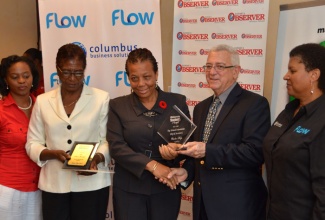 Minister of Education, Hon. Rev. Ronald Thwaites ( second right) presents Vice Principal, Oberlin High School, Audrey Francis (centre), with a trophy for being the top high school in the Eastern Region, during an awards luncheon held on October 25, at the Jamaica Observer’s headquarters in Kingston. Others (from left) are: Assistant Marketing Manager, Jamaica Observer, Pamille Shaw Blair; Principal, Oberlin High, Ivy Clarke; and Public Relations Manager, Flow, Jeanette Lewis. The luncheon was to honour approximately 22 teachers from the Eastern Region, who have assisted with the production and sales of the company’s educational publications.