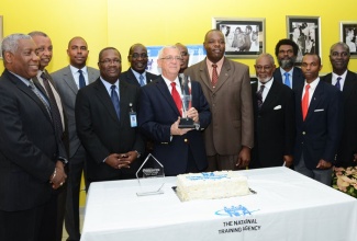 Minister of Education, Hon. Rev. Ronald Thwaites (holding trophy), with staff and Board members of the HEART Trust/NTA, on December 4 at the agency’s offices. Occasion was a celebration of the  agency  attaining the Jamaica Observer Business Leader 2013 award.