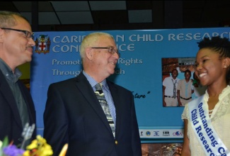 Minister of Education, Hon. Rev. Ronald Thwaites (centre), converses with 2012 Outstanding Caribbean Child Researcher, Raejean Porter, during Thursday’s (November 7) session of the Caribbean Child Research Conference at the Jamaica Conference Centre, downtown Kingston. Looking on at left is Director of the Sir Arthur Lewis Institute of Social and Economic Studies (SALISES), Professor Brian Meeks.