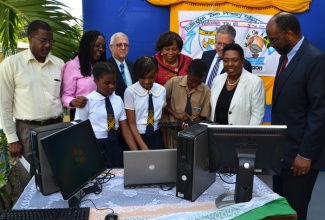 Minister of Education, Hon. Ronald Thwaites (3rd left), observes while students at the Rollington Town Primary School, in Kingston, (from left, front row), Bianca Clarke (left), Jaide Littleton, and Ziggy Adams test one of the 57 computers donated by The Globe and Mail, a Canadian media group, recently. Others (from left) are:  Chairman of the school Board, Garth Soares; Mayor of Kingston, Senator Angela Brown Burke; Principal of the school, Dr. Margaret Bailey; Canadian High Commissioner to Jamaica, His Excellency Robert Ready, Opposition Spokesperson on Youth, Culture and Gender Affairs, Olivia ‘Babsy’ Grange, and General Manager for the Jamaica National Building Society (JNBS), Mr. Earl Jarrett.  