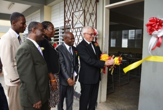 Minister of Education, Hon. Rev. Ronald Thwaites (right), cuts the ribbon to officially open the new classroom block at the Central High School in May Pen, Clarendon on February 12. Also pictured (from left) are: Head Boy at the school, Dorland Temple; Chairman of the school board, Beresford Sherman; Regional Director in the Ministry, Dr. Claudette Clarke; and Principal, Vinroy Harrison.