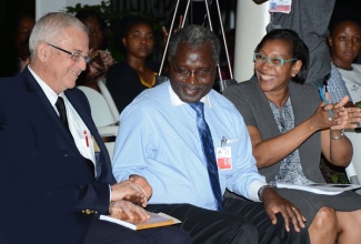 Education Minister, the Hon. Rev. Ronald Thwaites (left); greets Deputy Principal at the University of the West Indies, Mona campus, Ishenkumba Kahwa; while Head of the Department of Sociology, Psychology and Social Work, Dr. Heather Rickets, looks on. The Minister was guest speaker at the launch of a special issue of the Caribbean Journal of Social Work entitled, ‘Social Work & Development: Caribbean Insights,’ on October 23at the Undercroft, University of the West Indies (UWI), Mona Campus.