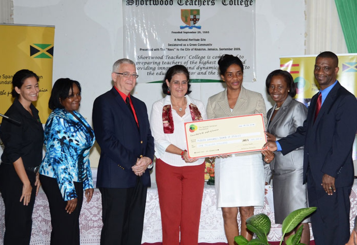 Minister of Education, Hon. Rev. Ronald Thwaites (3rd left), looks on as Spanish Ambassador to Jamaica and President of the Spanish-Jamaica Foundation (SJF), Her Excellency Celsa Nuño (centre), presents a cheque valued at $1 million to Vice Principal, Administrative Affairs, Shortwood Teachers’ College, Dossette Edwards-Watson (3rd right); Vice Principal, Academic Affairs, Church Teachers’ College, Monica Demster (2nd right); and Principal of Sam Sharpe Teachers’ College, Ashburn Pinnock (right). Occasion was the SJF Student Teachers Spanish Scholarship awards ceremony held today (Feb. 14), at the Shortwood Teachers’ College auditorium in St. Andrew. Sharing the moment (from left) are: General Manager, SJF, Dr. Rebecca Tortella; and Chairperson, Modern Languages Board of Studies, Teachers Colleges Jamaica, Aracelis Anedu. A total of 20 student teachers from the three teacher training institutions were awarded scholarships valued at $50,000, each, under the annual scholarship programme. 