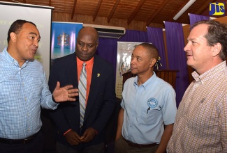 Health Minister, Dr. the Hon. Christopher Tufton (left), converses with (from 2nd left); Chairman, National Food Industry Task Force, Professor Fitzroy Henry; Private Sector Organization of Jamaica Chief Executive Officer, Denis Chung; and WYSINCO Group Director, Francois Chalifour, during Friday’s (November 3) national food industry stakeholder consultation meeting at the Bureau of Standards Jamaica head office in Kingston.