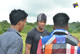 World Sprinter and YB Afraid Foundation Yohan Blake,  as he speaks to two of the boys of  Mt. Olivet Boys’ Home in Manchester on Saturday, December 17. 