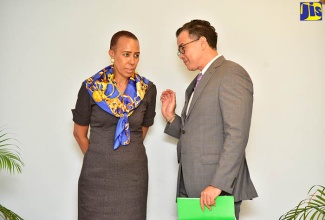 Minister without Portfolio in the Ministry of Finance and the Public Service, Hon. Fayval Williams (left), is in discussion with Chief Technical Director of the Financial Investigations Division (FID), Robin Sykes. Occasion was the 15th anniversary celebration of the FID at the University of the West Indies (UWI) Mona Visitors’ Lodge on Tuesday (May 22).