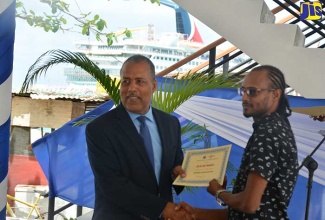 Port Authority of Jamaica President and Chief Executive Officer, Professor Gordon Shirley (left), presents a certificate to fisherman and business operator, Richard Morris, who participated in the Tourism Product Development Company’s recent training programme for stakeholders who will operate in the new state-of-the-art fishing village being developed in Ocho Rios, St. Ann.