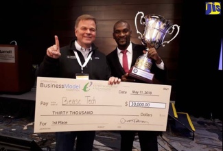 Founder and Chief Executive Officer for Beasc Technologies, Lancelot Riley (right), displays the International Business Model Competition (IBMC) champion’s trophy and winner’s cheque for US$30,000, which were presented to him by Founder and Chief Executive Officer for American firm, Alta Ventures, Paul Ahlstrom, during the 2018 IBMC, which took place in Utah, USA, from May 10 to 11. Beasc Technologies, which is affiliated with Northern Caribbean University (NCU), is the first Jamaican student-run business entity to win the IBMC, which is staged annually for tertiary institutions.   