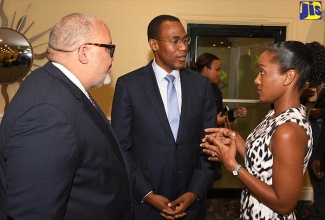 Minister of Finance and the Public Service, Dr. the Hon. Nigel Clarke (centre) converses with Partner, Hart Muirhead and Fatta, Sanya Goffe (right), during the Pension Funds Association of Jamaica's annual luncheon at The Knutsford Court Hotel in New Kingston on May 16. At left is Director, Pension Funds Association of Jamaica, Peter Goldson.