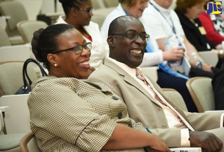 Minister of Education, Youth and Information, Senator the Hon. Ruel Reid and Pan American Health Organization (PAHO)/World Health Organization (WHO) Representative in Jamaica, Dr. Noreen Jack, share a light moment at the opening of the ‘Nursing and Midwifery Conference’ of  the University of the West Indies School of Nursing today (May 24), at the Mona campus.