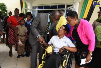 Minister of Education, Youth and Information, Senator the Hon. Ruel Reid (left), and Minister of Culture, Gender, Entertainment and Sport, Hon. Olivia Grange (right), greet Therese Braham after the National Workers’ Week and Labour Day church service at the Portmore Holiness Christian Church, Hellshire, St. Catherine, on May 20. 