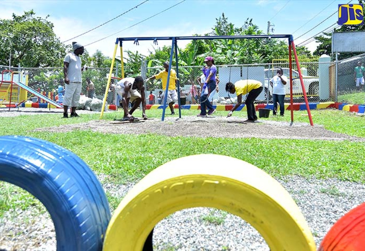 Volunteers  pave the play area at the St. Ann’s Bay Infant School in St. Ann, which was one of the national  projects for Labour Day on May 23.