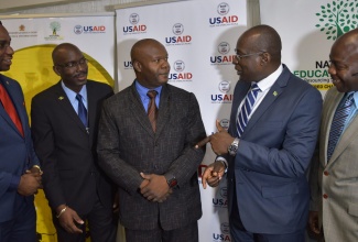 Minister of Education, Youth and Information, Senator the Hon. Ruel Reid (second right) emphasises a point  to (from left): Permanent Secretary in the Education Ministry, Dean-Roy Bernard; Director of Safety and Security in Schools, Assistant Superintendent of Police, Coleridge Minto; Detective Inspector Clifton Green of the Gang Unit of the Counter Terrorism and Organized Crime Branch (C-TOC); and Acting Commander of C-TOC, Superintendent of Police Anthony McLaughlin. Occasion was the launch of the first in a series of anti-gang workshops at the Jamaica Pegasus Hotel in New Kingston on Friday (May 18).