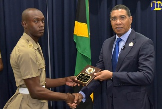 Prime Minister, the Most Hon. Andrew Holness (right), presents a special award to Private Odaine Thorpe for displying outstanding leadership and academics, proper dress and deportment, and the core values of the Jamaica Defence Force (JDF). Occasion was the certification ceremony for the first 208 privates in the Jamaica National Service Corps (JNSC) programme, held on June 26 at Up Park Camp in Kingston.