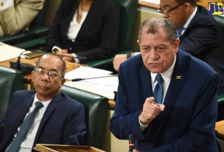 Minister of Industry, Commerce, Agriculture and Fisheries, Hon. Audley Shaw, contributes to debate on the Report of the Commission to Review Jamaica’s Relations within the CARICOM and CARIFORUM Frameworks in the House of Representatives on June 19. At left is Minister of National Security, Hon. Dr. Horace Chang. 
 
