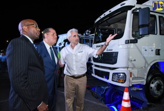 JN Bank Managing Director, Curtis Martin (left), are briefed on specifications of the Chinese-manufactured SHACMAN heavy-duty trucks by Chief Executive Officer of the Tank-Weld Group, Chris Bicknell, during Monday’s (June 25) launch of the local dealership at the Spanish Court Hotel, New Kingston. SHACMAN Jamaica comprises a partnership with the Tank-Weld Group, the country’s largest supplier of building materials, through its subsidiary Tank-Weld Equipment. JN Bank is facilitating loans for prospective clients.