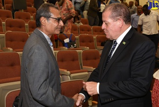 Minister of Industry, Commerce, Agriculture and Fisheries, Hon. Audley Shaw (right), greets Professor, Caribbean Network for Urban and Land Management at the University of the West Indies, Dr. Asad Mohammed, at the Caribbean Urban Forum 2018 held at the University of Technology, on June 27.