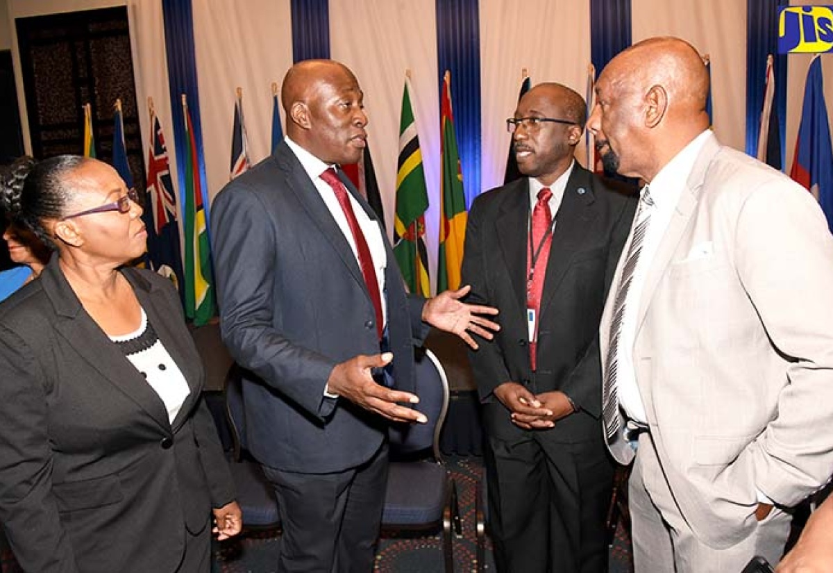 Minister of State in the Ministry of National Security,  Hon. Rudyard Spencer (right), in discussion with Chief Justice of Jamaica, Hon. Bryan Sykes (second left), at the opening ceremony for the Association of Caribbean Heads of Corrections and Prison Services (ACHCPS) Conference,  at The Jamaica Pegasus hotel in New Kingston on Monday (June 11). Others (from left) are: Commissioner of Corrections, Ina Hunter-Fairweather; and President, (ACHCPS), Lieutenant Colonel John Nurse.