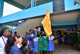 Minister of Education, Youth and Information, Senator the Hon. Ruel Reid (centre), unveils plaque in memory of the late Enid Bennett at the Enid Bennett High School in Bog Walk, St. Catherine, immediately after the school was renamed, on Tuesday (June 19). 