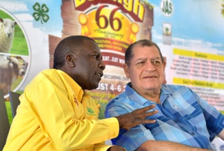 Industry, Commerce, Agriculture and Fisheries Minister, Hon. Audley Shaw ( right) listens attentively to a point being made by Jamaica Agricultural Society (JAS) President, Norman Grant, at the launch of the 66th staging of the Denbigh Agricultural, Industrial and Food Show, at the Hi-Pro Supercentre in White Marl, St. Catherine on June 15.