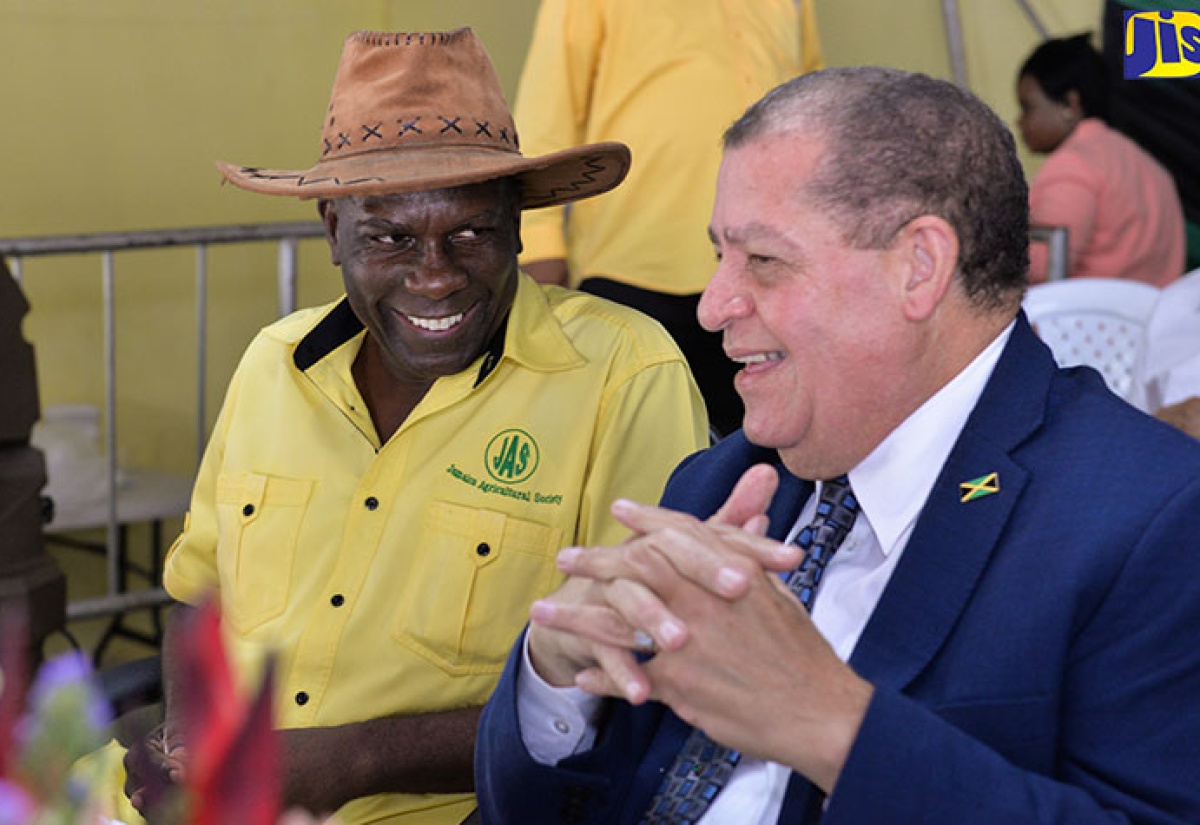 Industry, Commerce, Agriculture and Fisheries Minister, Hon. Audley Shaw (right), and Outgoing President of the Jamaica Agricultural Society (JAS), Norman Grant, engage in light conversation at the JAS's 123rd annual general meeting, held at the Denbigh showground in May Pen, Clarendon, on July 11.