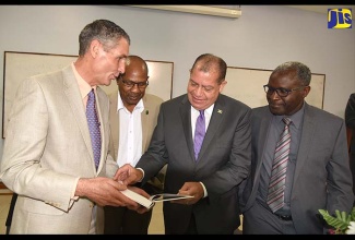 Industry, Commerce, Agriculture and Fisheries Minister, Hon. Audley Shaw (second right), peruses a publication on crop modelling during Monday’s (July 23) launch of the Pilot Programme for Climate Resilience (PPCR) Advanced Training Workshop on Crop Modelling at the Department of Physics, University of the West Indies (UWI), Mona Campus, St. Andrew. Mr. Shaw was the keynote speaker. Others (from left) are pre-eminent scholar from the Institute for Sustainable Food Systems, University of Florida, USA, Professor Gerrit Hoogenboom; Caribbean Agriculture Research Development Institute (CARDI) Jamaica Representative, Dr. Gregory Robin; and UWI Mona Campus Deputy Principal, Professor Ishenkumba Kahwa.