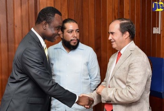 Permanent Secretary in the Ministry of Education, Youth and Information, Dean-Roy Bernard (left), greets Mexico’s Ambassador to Jamaica, His Excellency Juan José Gonzalez Mijares (right), at Thursday’s (July 19) launch of the ‘Project for Capacity Development in Digital Preservation for Records and Information Professionals’, at the Ministry in Kingston.  At centre is Director for Information Technology at the General National Archives of Mexico,  Erick Cardoso Espinosa. 