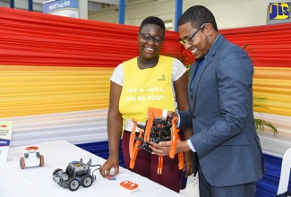 State Minister for Education, Youth and Information, Hon. Floyd Green (right), examines a mobile robot during the opening ceremony for World Youth Skills Day 2018 on July 17 at the HEART Trust/NTA’s Garmex Academy in Kingston. Looking on is second-year student in Industrial Systems, Operations and Maintenance at the Caribbean Maritime University (CMU), Jenelle Hinds. 