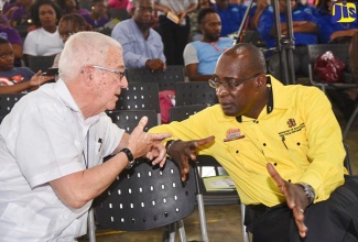 Minister of Education, Youth and Information, Senator the Hon. Ruel Reid (right), is in discussion with Opposition Spokesman on Education and Training, the Reverend Ronald Thwaites, at the National Parent-Teacher Association of Jamaica (NPTAJ) Sixth biennial general meeting and national conference held on Saturday (July 14), at Jamaica College in St. Andrew.