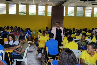 Universal Service Fund (USF) Chief Executive Officer, Suzette Buchanan, interacting with the students participating in the USF’s Technology Advancement Programme training session at the Young Women’s Christian Association in Kingston  in April.