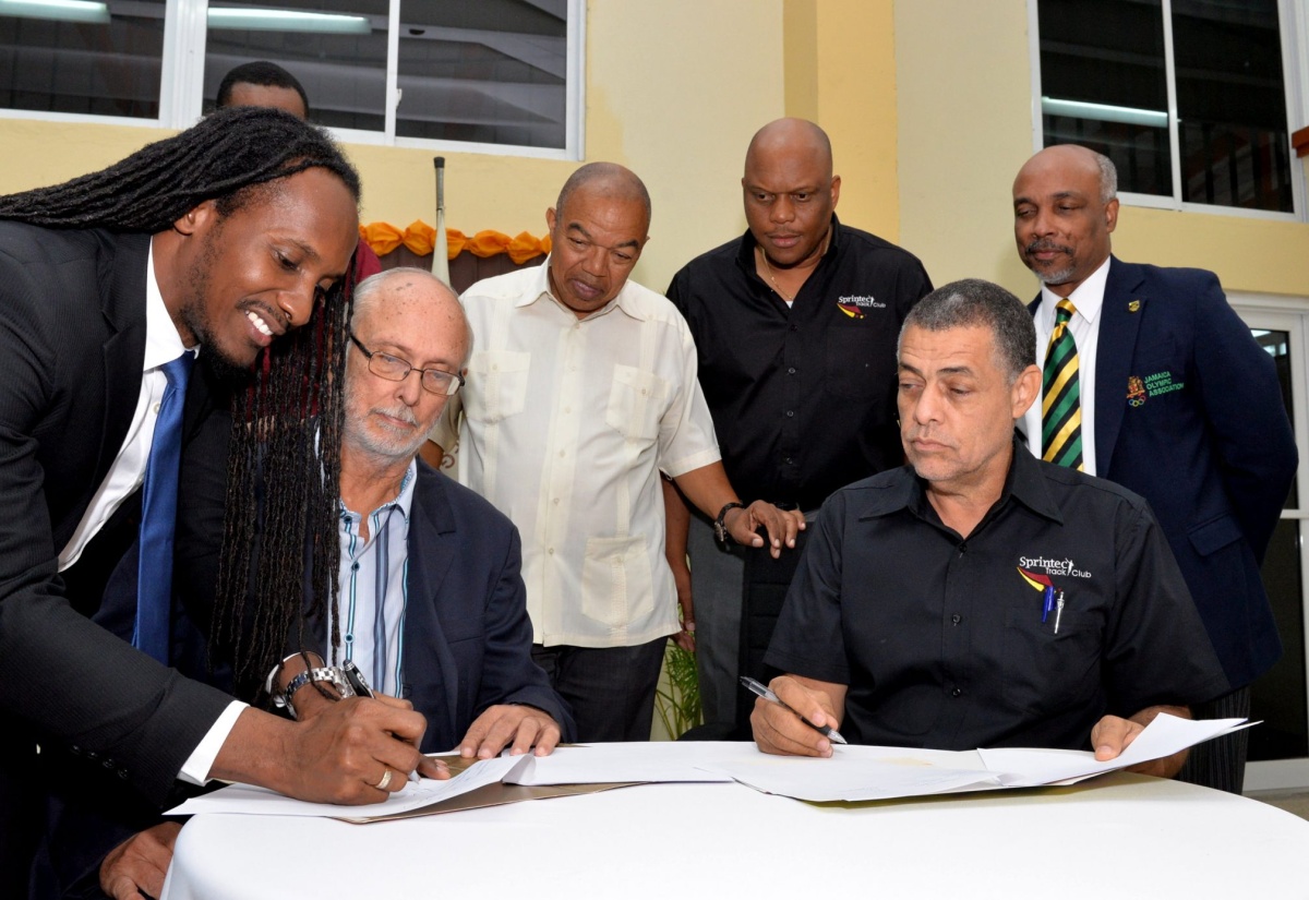 State Minister in the Culture, Gender, Entertainment and Sport Ministry, Hon. Alando Terrelonge (left), co-signs the Memorandum of Understanding between the G.C. Foster College of Physical Education and Sport, and Sprintec Track Club, during a ceremony at the College’s Campus in Angels, St. Catherine, on Friday (August 24). Others looking on (from 2nd left) are: College Chairman, David Mais; President, Jamaica Athletic Administrative Association, (JAAA), Dr. Warren Blake; Acting College Principal, Maurice Wilson; Sprintec Chairman, Dr. Paul Auden; and Jamaica Olympic Association (JOA) President, Christopher Samuda.