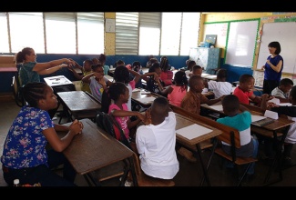 Students of Ne Providence Primary School in Kingston and their teacher, Nicole Thomson (left, background), take part in a Mathematics lesson with PR1ME Mathematics Specialist, Kelly Lim Kai Ling (right), recently at the school. The class was sponsored by the Rotary Club of Liguanea Plains and The Book Merchant Limited (BML). Ms. Lim Kai Ling was in Jamaica as the leading facilitator at the second staging of BML’s ‘Amazing Mathematics Powers (AMP)… PR1MEd for Success’ workshop for teachers that was held at the Shortwood Teachers’ College in Kingston from August 21 to 23.