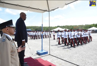 State Minister for National Security, Hon. Rudyard Spencer (second left), watches as constables take part in a passing out parade at the National Police College of Jamaica in Twickenham Park, St. Catherine, on August 17. At left is Police Commissioner, Major General Antony Anderson. 