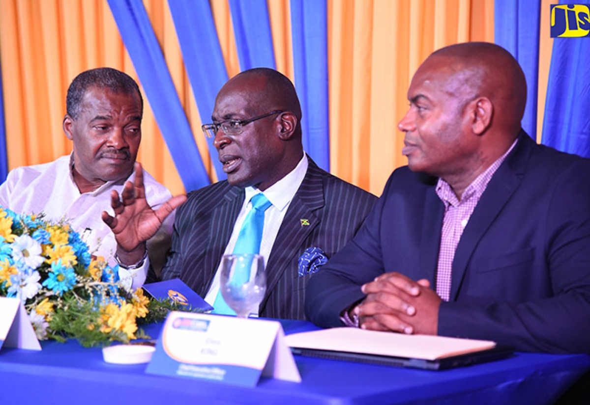 Education, Youth and Information Minister, Senator the Hon. Ruel Reid (centre), makes a point to President of EduCom Co-op Credit Union, C. Leopold Nesbeth (left), at the credit union’s 2018 scholarship awards ceremony at The Knutsford Court Hotel in New Kingston on August 15. At right is Chief Executive Officer (CEO) of EduCom, Elvis King.