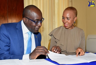 Education, Youth and Information Minister, Senator the Hon. Ruel Reid (left), converses with Minister without Portfolio in the Ministry of Finance and the Public Service, Hon. Fayval Williams, at Wednesday’s (August 29) post-Cabinet press briefing held at Jamaica House.