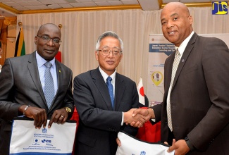 Education, Youth and Information Minister (MOEYI), Senator the Hon. Ruel Reid (left), along with Counsellor, Embassy of Japan in Jamaica, Shinichi Yamanaka (centre), who presented an information kit for the Professional Development Programme for MOEYI Mathematics Specialists and Teacher Educators to Principal, Moneague Teachers’ College, Howard Isaacs, during the initiative’s launch on Thursday (August 16) at the Mona Visitors’ Lodge in St. Andrew.