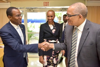 Finance and the Public Service Minister, Dr. the Hon. Nigel Clarke (left), greets Bank of Jamaica (BOJ) Governor, Brian Wynter,  at the Terra Nova All-Suite Hotel in St. Andrew for the second annual National Financial Inclusion Council Meeting and Forum, recently. Dr. Clarke chairs the Council, while Mr. Wynter is Chairman of the Financial Inclusion Steering Committee. At centre is Minister without Portfolio in the Ministry of Finance and the Public Service, Hon. Fayval Williams.