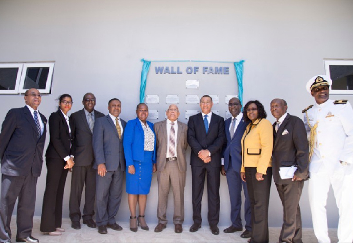 Prime Minister Andrew Holness stands by the Wall of Fame at the FESTO FACT Centre at Caribbean Maritime University along with other persons who were instrumental in the establishment of the centre. (Left to right) Dr Wesley Hughes, Shakierah Cowan, Dr Alwyn Hayles, Phillip Paulwell, Dr Grace McLean, Dr Omar Davies, Senator Ruel Reid, Mrs Audrey Sewell, Rev. Wellesley Blair & Professor Fritz Pinnock. 