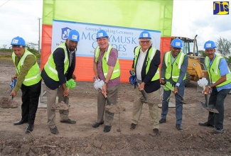 Minister without Portfolio in the Ministry of Economic Growth and Job Creation, Hon. Karl Samuda (third right); and Minister of Industry, Commerce, Agriculture and Fisheries, Hon. Audley Shaw (third left), break ground  for a new housing development, Monymusk Glades, in Jacksonville, Clarendon, on Wednesday (Sept. 12). Also participating (from left) are: Mayor of May Pen, Councillor Winston Maragh; Member of Parliament for Clarendon South Eastern, Hon. Rudyard Spencer; Board Chairman, National Housing Trust, Lennox Channer; and Director, SCJ Holdings Limited (SCJH), Horace Charoo. The development, which is a joint venture between NHT and SCJH, involves the construction of 84 serviced lots.