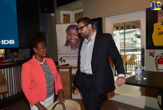 Lead Economist at the Inter-American Development Bank (IDB), Dr. Henry Mooney, converses with President of the Business Process Industry Association of Jamaica (BPIAJ), Gloria Henry, prior to the start of the association’s 'Presidents Forum' on Thursday, October 4 at Usain Bolt Tracks & Records in Montego Bay, St. James.