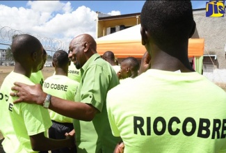 Minister of State in the Ministry of National Security, Hon. Rudyard Spencer (centre), interacts with wards at the Rio Cobre Juvenile Correctional Centre in Spanish Town, St. Catherine, during a visit in August, to participate in the ‘We Transform’ sports day