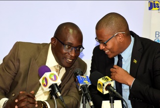 Minister of Education, Youth and Information, Senator the Hon. Ruel Reid (left), engages with Minister of State, Hon. Floyd Green, just before the start of a press conference at the Ministry’s National Heroes Circle offices in Kingston on October 3.